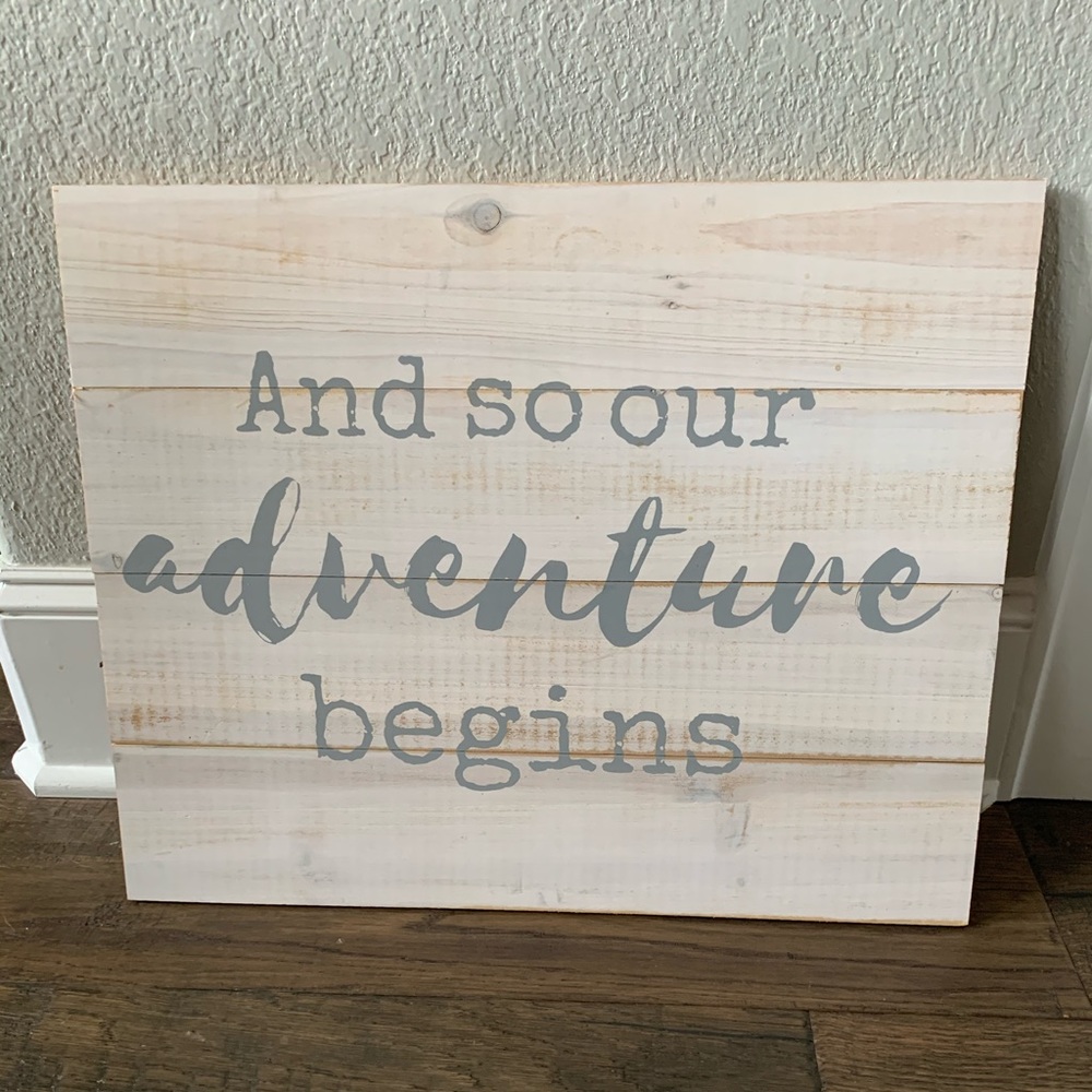 “And so our adventure begins” sign